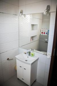 a white bathroom with a sink and a shower at Apartament 250m od morza! in Ustka