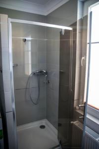 a shower with a glass door in a bathroom at Apartament 250m od morza! in Ustka