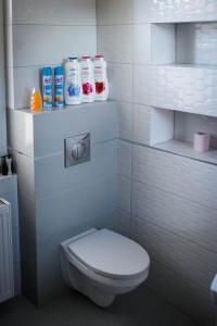 a bathroom with a toilet and some cleaning products at Apartament 250m od morza! in Ustka
