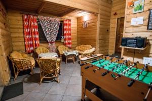 ポロニンにあるWilla pod Jodłąのキャビン内のゲームテーブルと椅子付きの部屋