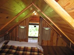 un letto nella mansarda di una cabina in legno di Holiday Home Carovina a Paradiž