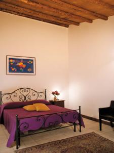 a bedroom with a purple bed in a room at Agriturismo Sirignano Wine Resort in Sirignano