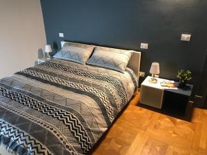 a large bed in a bedroom with a night stand at Modena Charme Sant'Eufemia in Modena