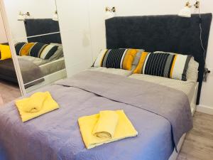 uma cama com toalhas amarelas em frente a um espelho em Studio Dworzec Gdański em Varsóvia
