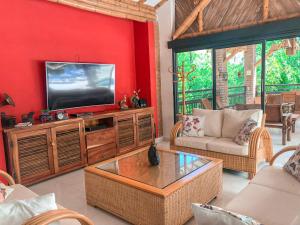 a living room with a flat screen tv on a red wall at Finca Panaca Herrería 8 in Quimbaya