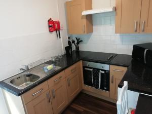a kitchen with a sink and a stove at Rockville Amlwch LL68 0TE, UK Apartment in Llanfflewyn