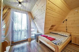 Dom Rodzinny في زومب: غرفة نوم بسرير في غرفة خشبية مع نافذة