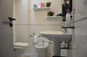 La salle de bains blanche est pourvue d'un lavabo et de toilettes. dans l'établissement Casa Lucia, à Agnone Bagni