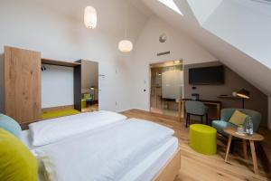 a bedroom with a large white bed and a table at zum LOEWEN in Eimeldingen