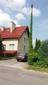 a car parked in front of a house with a tall tree at villa in Nowa Ruda