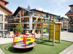 a playground in front of a apartment building at Smiltelės Apartamentai Booking Palanga LT in Palanga