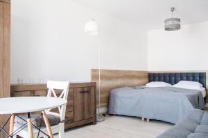 una camera con letto, tavolo e sedia di Silver Apartments a Sarbinowo