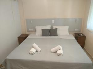 a bedroom with a large white bed with towels on it at Despoina Rooms in Tsoukalades