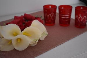 un grupo de copas rojas y flores en una mesa en Fantasy Apartment, en Korčula