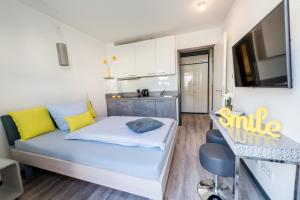 a small bedroom with a blue bed and yellow pillows at Design-Apartments by Ulrike Horster in Bensheim