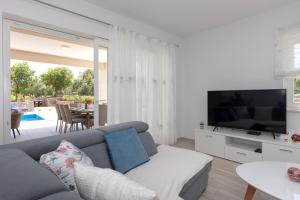 a living room with a couch and a tv at Villa Magdalena in Porat
