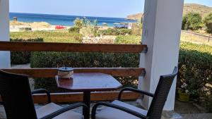 una mesa y sillas en un balcón con vistas al océano en Tramonto Nel Delfini, en Kini