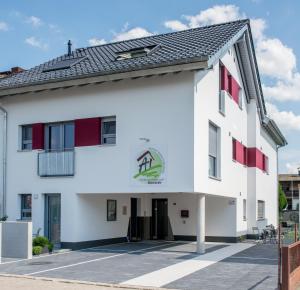 um edifício branco com janelas vermelhas e um telhado em Apartmenthaus Horster em Bensheim