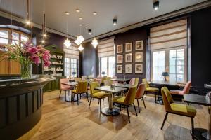 a restaurant with tables and chairs and a bar at Boutique Hotel KRISTOFS in Riga