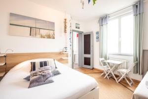 a white bedroom with a bed and a table and chairs at VILLA ZENITH Hostel - LA MAISON in Lacanau