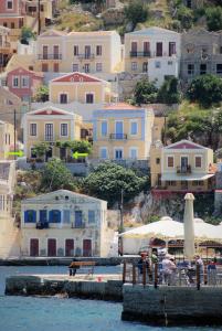 a group of houses on a hill next to the water at Pitini Sevasti house in Symi