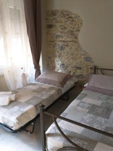 two beds in a room with a stone wall at Casa D'amore in Riomaggiore
