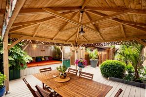 a wooden patio with a wooden table and chairs at VILLA ZENITH Hostel - LA MAISON in Lacanau