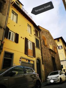 two cars parked in front of a yellow building at Terrazza Giraldi in Florence