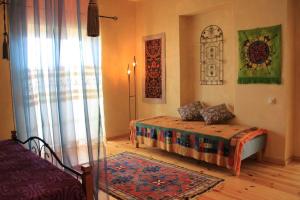 Schlafzimmer mit einem Bett, einem Fenster und einem Teppich in der Unterkunft Villa Kursa in Sighnaghi
