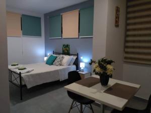 a bedroom with a bed and a table and a tableablish at Summer Studio - Zakynthos!! in Argassi