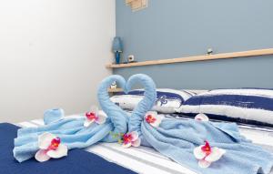 a bed with blue towels and flowers on it at Apartman Sunrise in Vela Luka