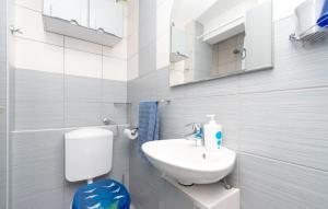 a white bathroom with a sink and a toilet at Apartman Sunrise in Vela Luka
