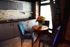 una cocina con una mesa con sillas y un jarrón de flores en Apartamenty Centrum RS SUITES Kowalska 12 en Lublin