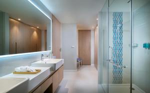 ein Badezimmer mit Waschbecken und Dusche in der Unterkunft OZO Phuket in Kata Beach