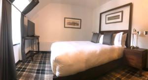 a hotel room with a bed and a television at Edinbane Lodge in Edinbain
