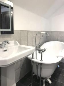 a bathroom with two sinks and a bath tub at Edinbane Lodge in Edinbain
