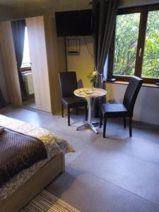 a bedroom with a bed and a table and chairs at Votre Horizon in Aywaille