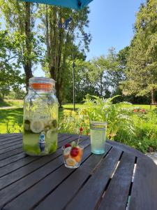 una jarra de fruta y una bebida en una mesa de madera en La Caillerie, en Chauvé