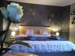 een slaapkamer met een blauw bed met een bloem aan de muur bij Votre Horizon in Aywaille