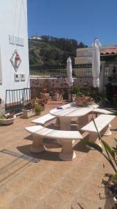 un groupe de tables avec parasols sur un patio dans l'établissement Moradia Valdemar, à Nazaré