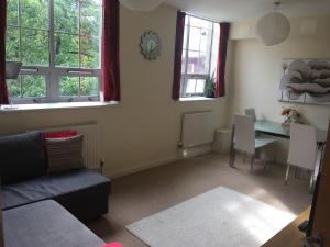 sala de estar con sofá, mesa y ventanas en Superb Peaceful 1 bed apartment in St George., en Bristol