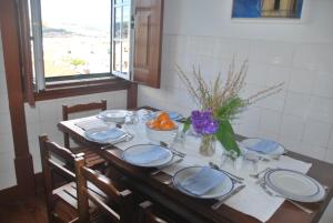 una mesa de comedor con platos azules y blancos. en Sol Nascente, en Coímbra