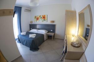 a small bedroom with a bed and a mirror at Albergo Moschella in Lampedusa