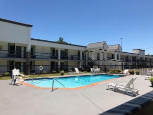 a swimming pool in front of a large building at Quality Inn in Dalton