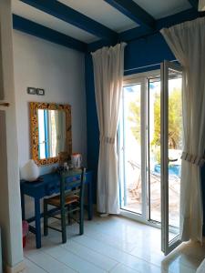um quarto azul com uma mesa e um espelho em Il Canto delle Cicale em Agia Marina