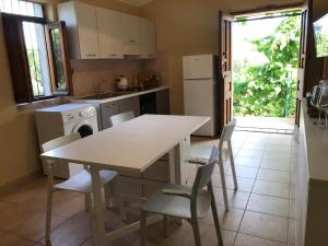 a kitchen with a table and chairs and a refrigerator at Arancetodamare_POSEIDONE in Trebisacce