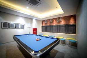 a billiard room with a pool table and stools at PALM PARK Hotel Surabaya in Surabaya