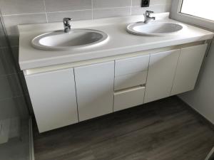 a white bathroom with two sinks and a mirror at Vakantiewoning De Zandkorrel in Middelkerke +24 photos