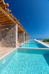 een infinity pool met een stenen muur en blauw water bij Atermono Boutique Resort & Spa in Platanes