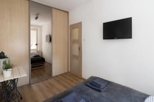 a bedroom with a large mirror and a tv on the wall at THE HEART OF NOWA HUTA - free garage in Krakow